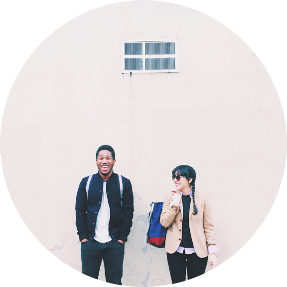 a man and a woman laughing standing beside a wall